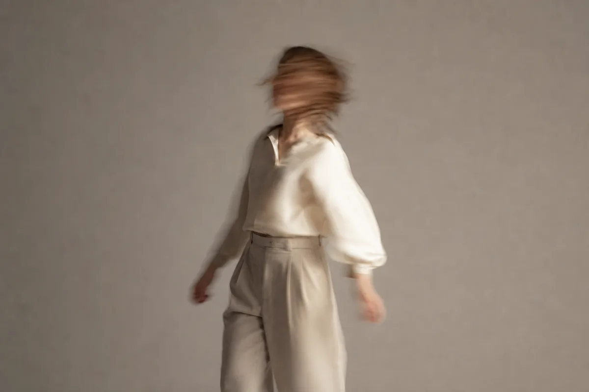 Modèle en léger flou de mouvement entre deux poses dans un studio épuré